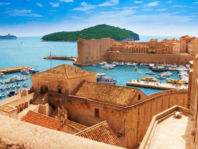 Τα τείχη της παλιάς πόλης του Ντουμπρόβνικ στην Κροατία με το λιμάνι γεμάτο σκάφη και το φρούριο Λοβριγιένατς στο βάθος